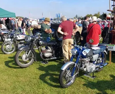 A line of vintage motorcycles parked at the classic motorcycle exhibit