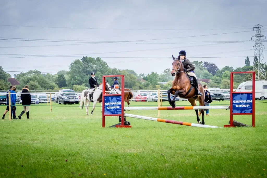 A rider mid-course tackling a fence during a show jumping round